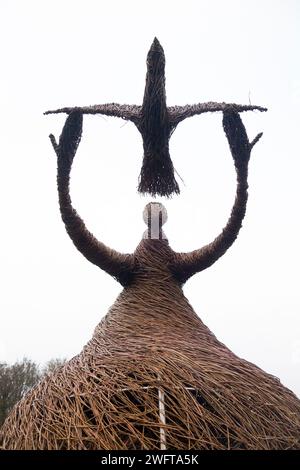 Scultura di una donna che rilascia uccello (forse una colomba di pace), realizzata con rami di salice, dall'artista Willowtwisters in residenza, in mostra a Runnymede, nel Surrey. REGNO UNITO. Foto Stock