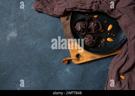 Vista dall'alto dei dolci al tartufo di cioccolato su un piatto opaco scuro su una tavola di legno Foto Stock