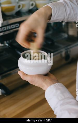 Primo piano, il barista prepara il matcha. Il processo di lavoro di un barista in un bar. Foto Stock
