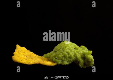 Nacho con guacamole in orizzontale con sfondo nero e piatti messicani Foto Stock