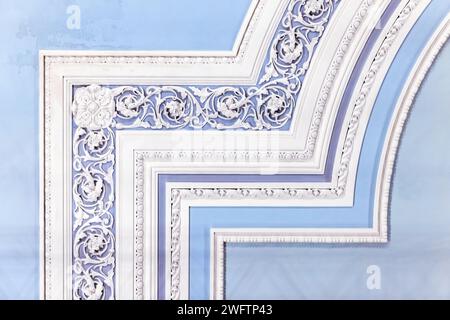 Parete blu chiaro con decorazione classica in stucco, frammento interno astratto con ornamento floreale Foto Stock