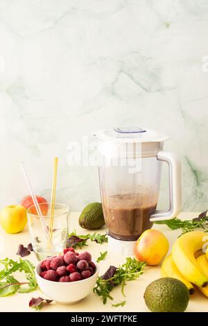 Colazioni salutari, frullati salutari e deliziosi con ciliegie e banane surgelate e avocado, proteine della piselli e verdure miste, frullato bicchiere mixer Foto Stock
