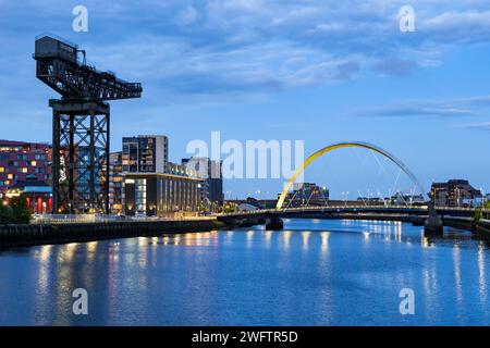 Finnieston Crane e Clyde Arc bridge sul fiume Clyde al crepuscolo nella città di Glasgow in Scozia, Regno Unito. Foto Stock