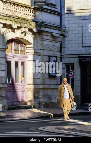 Uomo ben vestito che cammina attraverso la luce del sole nel centro della città - Tours, Indre-et-Loire (37), Francia. Foto Stock