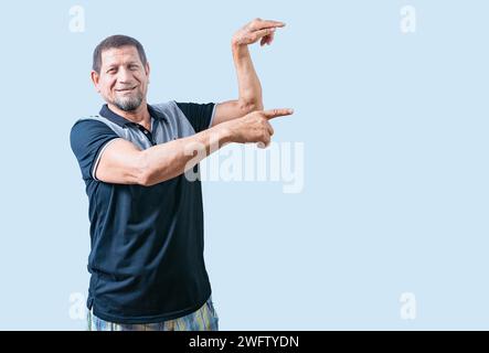 Uomo anziano felice che indica uno spazio pubblicitario isolato. Un uomo anziano sorridente che indica il lato isolato Foto Stock