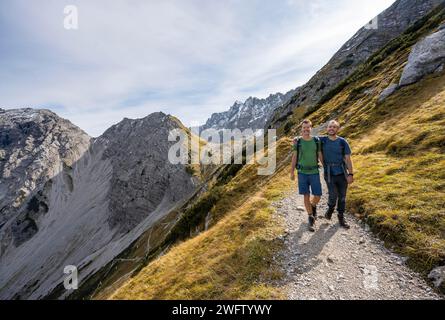 Due alpinisti allegri e amichevoli su un sentiero escursionistico, che porta a Lamsenjochhuette, Ing, Karwendel, Tirolo, Austria Foto Stock