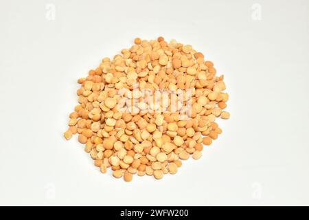 I semi di piselli sbucciati ed essiccati si trovano in un mucchio su uno sfondo bianco. Foto Stock