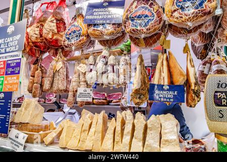 Salumi e formaggi in vendita presso una gastronomia all'interno del mercato centrale di Firenze, un mercato di prodotti e prodotti freschi molto frequentato a Firenze, Italia Foto Stock