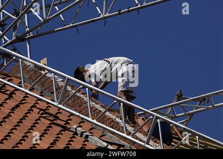 KASTRUP/COPENHAGEN/DANIMARCA   lavoratore edile maschio che lavora sul tetto preparando tegole 17 giugno 2013 Foto Stock