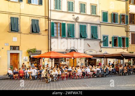 Le persone sedute all'esterno si godono cibo e bevande nei ristoranti e bar di Piazza Santo Spirito, nel quartiere Oltrano di Firenze, Italia Foto Stock