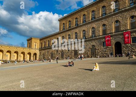 Persone sedute sul cortile nel tardo pomeriggio al sole di Palazzo Pitti a Firenze, Italia Foto Stock