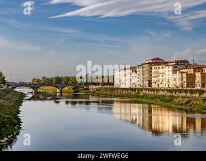 Gli edifici che si riflettono sul fiume Arno nel tardo pomeriggio illuminano il sole di Firenze, Italia Foto Stock