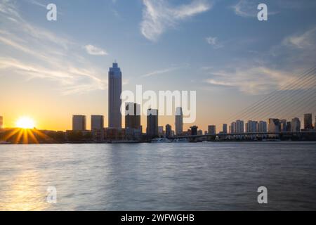 Skyline della città di Rotterdam durante il tramonto sotto un cielo nuvoloso blu Foto Stock