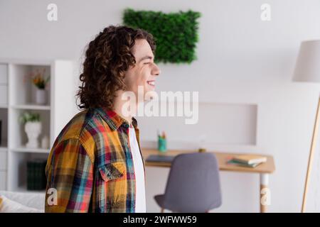 Foto di un ragazzo allegro di buon umore vestito camicia a scacchi sorridente che si gode il weekend in casa Foto Stock