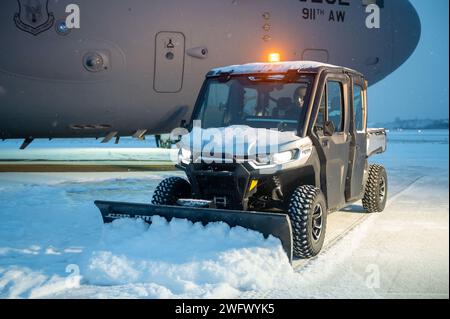 Il Senior Airman Brandon Parker, un capo dell'equipaggio del 911th Aircraft Maintenance Squadron, gestisce una spazzaneve CAN-AM per liberare la neve da un 911th Airlift Wing assegnato al C-17 Globemaster sulla flightline presso la Pittsburgh International Airport Air Reserve Station, Pennsylvania, 16 gennaio 2024. I membri del 911th AMXS si affidano a veicoli affiancati e pale da neve per pulire la neve nelle aree vicine agli aeromobili che i veicoli più grandi non possono raggiungere, garantendo un'accurata rimozione dei pericoli. Foto Stock