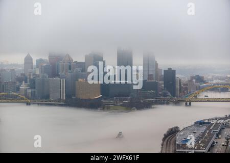 Una towboat naviga attraverso la nebbia del fiume Ohio a Pittsburgh, 25 gennaio 2024. Il U.S. Army Corps of Engineers Pittsburgh District gestisce 23 chiuse navigabili e dighe sui fiumi Allegheny, Monongahela e Ohio tutto l'anno, indipendentemente dalle condizioni meteorologiche, anche in condizioni di nebbia che limitano la visibilità. Molti equipaggi di barche a rimorchio continuano a lavorare sui fiumi anche nella nebbia, talvolta mettendo in scena le loro chiatte lungo varie parti lungo i corsi d'acqua di Pittsburgh mentre aspettano che la nebbia si sollevi. Indipendentemente dal tempo, le chiuse e le dighe del distretto di Pittsburgh rimangono aperte al traffico, pronte ogni volta Foto Stock