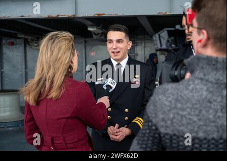 Royal Australian Navy Ltd. James Heydon, diplomato a Charleston presso la Nuclear Power Training Unit della Marina degli Stati Uniti, è intervistato da membri della stampa australiana a bordo della USS Yorktown (CV 10) presso il Patriots Point Naval and Maritime Museum di Mt. Pleasant, South Carolina, 12 gennaio 2024. Durante la cerimonia, i primi tre ufficiali della Royal Australian Navy si sono diplomati presso la scuola, segnando un passo significativo nell'obiettivo dell'Australia di operare sottomarini d'attacco dotati di armi convenzionali e di energia nucleare. Foto Stock