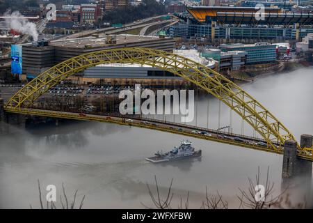 Una towboat naviga attraverso la nebbia sotto il West End sul fiume Ohio a Pittsburgh, 25 gennaio 2024. Il U.S. Army Corps of Engineers Pittsburgh District gestisce 23 chiuse navigabili e dighe sui fiumi Allegheny, Monongahela e Ohio tutto l'anno, indipendentemente dalle condizioni meteorologiche, anche in condizioni di nebbia che limitano la visibilità. Molti equipaggi di barche a rimorchio continuano a lavorare sui fiumi anche nella nebbia, talvolta mettendo in scena le loro chiatte lungo varie parti lungo i corsi d'acqua di Pittsburgh mentre aspettano che la nebbia si sollevi. Indipendentemente dalle condizioni meteorologiche, le chiuse e le dighe del distretto di Pittsburgh rimangono aperte al traffico Foto Stock