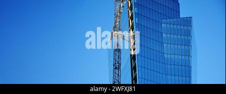 Vilnius (Lituania) - moderni grattacieli in vetro in costruzione. Angolo di ripresa insolito. Cielo limpido, riflessi nelle finestre Foto Stock