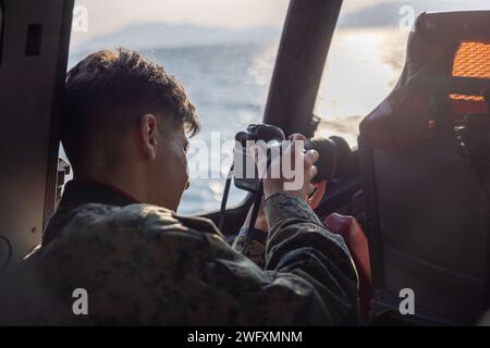 U.S. Marine Corps Lance Cpl. Colin Thibault, un videografo da combattimento con Headquarters and Headquarters Squadron, Marine Corps Air Station Iwakuni, registra i piloti giapponesi della forza di autodifesa marittima ShinMaywa US-2 durante il volo annuale di Capodanno JMSDF al MCAS Iwakuni, Giappone, 5 gennaio 2024. Il volo di Capodanno della JMSDF si svolge tipicamente all’inizio di gennaio, e il volo di quest’anno ha mostrato le capacità degli US-2, nonché la capacità del Fleet Air Wing 31 di condurre rapidamente e con successo missioni di ricerca e salvataggio. Questa è la prima volta in 9 anni l'evento si tiene a Iwakuni. Foto Stock