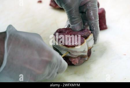 St Louis, Stati Uniti. 5 febbraio 2024. Il macellaio Jim Legrand attacca una striscia di pancetta a una bistecca mignon di filetto a forma di cuore da 250 ml che sta preparando per lo speciale del negozio, cena per due, per San Valentino al Legrand's Market di St. Louis giovedì 1 febbraio 2024. Per $60 Legrand's preparerà un pasto completamente cotto che include due bistecche a forma di cuore, broccoli, carbonara di pasta, insalata e mini torte al formaggio, perfetto per due. Foto di Bill Greenblatt/UPI credito: UPI/Alamy Live News Foto Stock