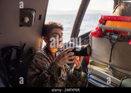 U.S. Marine Corps Lance Cpl. Colin Thibault, un videografo da combattimento con Headquarters and Headquarters Squadron, Marine Corps Air Station Iwakuni, registra i piloti giapponesi della forza di autodifesa marittima ShinMaywa US-2 durante il volo annuale di Capodanno JMSDF al MCAS Iwakuni, Giappone, 5 gennaio 2024. Il volo di Capodanno della JMSDF si svolge tipicamente all’inizio di gennaio, e il volo di quest’anno ha mostrato le capacità degli US-2, nonché la capacità del Fleet Air Wing 31 di condurre rapidamente e con successo missioni di ricerca e salvataggio. Questa è la prima volta in 9 anni l'evento si tiene a Iwakuni. Foto Stock