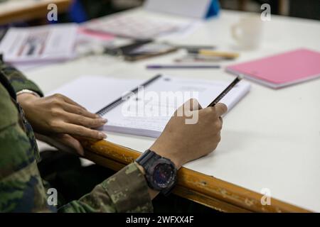 Royal Thai Navy Chief Petty Officer 1st Class Aphinyarawee Aupathum, uno studente del Thailand Mine Action Center (TMAC), prende appunti durante un corso Explosive Ordnance Disposal (EOD) Level 1-2 a Fort Bhanurangsi, Ratchaburi, Thailandia, 9 gennaio 2024. Le forze armate tailandesi e americane lavorano insieme per formare gli studenti TMAC nel livello EOD 1-2 al fine di sviluppare una capacità EOD per assistere la missione di TMAC di diventare senza mine terrestri. Questa partnership è in linea con il programma di azione umanitaria contro le mine del Dipartimento della difesa degli Stati Uniti, che assiste le nazioni partner colpite dalle mine terrestri, remnan esplosivo Foto Stock