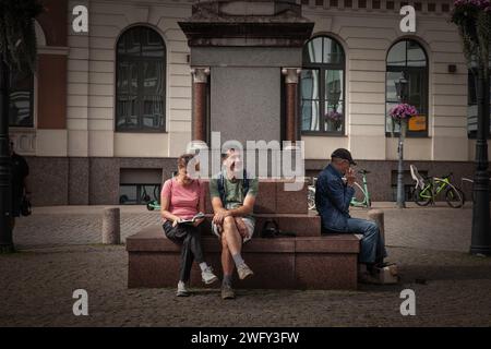 Foto di due turisti, una coppia di mezza età, seduti e riposati nel centro della città di riga, lettonia. Foto Stock