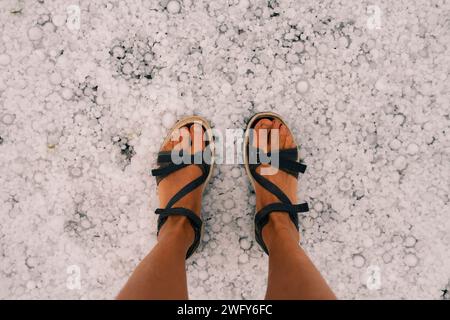 gambe nello spesso strato di grandine sul terreno. Foto di alta qualità Foto Stock