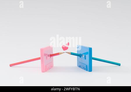 Sei la matita della mia cassetta. Vecchi nastri e matite rosa e blu che si baciano. Concetto d'amore minimalista. Idea creativa di cassette. Foto Stock