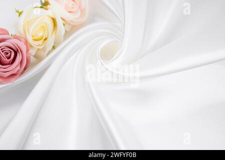 Fiore rosa di rose su sfondo bianco di seta. I concetti di San Valentino. Foto Stock