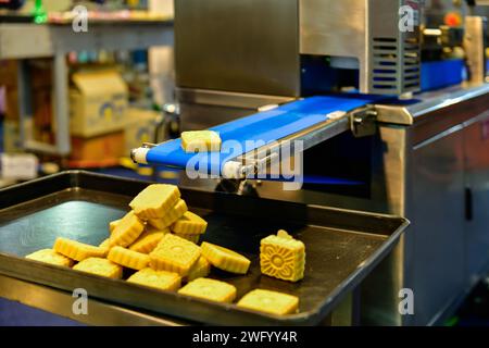 Linea di produzione automatica di snacks dorati su macchine per nastri trasportatori in fabbrica, produzione alimentare industriale. Foto Stock