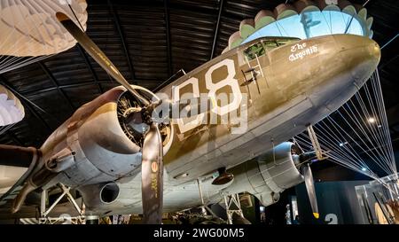 Un grande aereo parcheggiato nell'hangar con persone nelle vicinanze Foto Stock