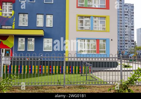 Facciata dell'edificio dell'asilo. Parco giochi colorato per bambini in una giornata di sole Foto Stock