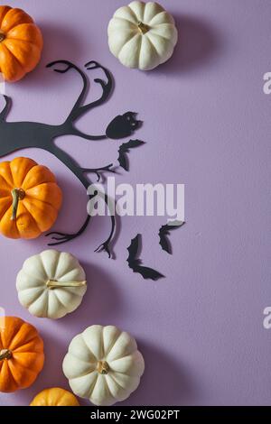 Zucche bianche e arancioni su sfondo viola con gufo di carta e pipistrello. Decorazione di Halloween. Posizione piatta Foto Stock