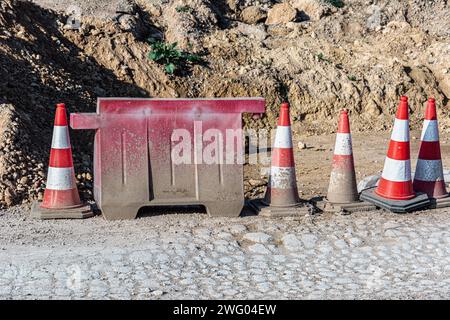 I coni di circolazione multipli posti su una strada adiacente a un cumulo di sabbia Foto Stock