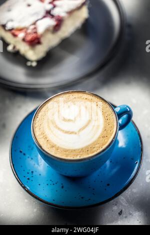 Caffè cappuccino tradizionale con torta sul tavolo del caffè. Foto Stock
