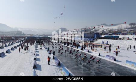 I piloti competono nella gara di pattinaggio durante la prima China Jilin Songhua River Ice Skating Marathon nella contea di Jingyu, Baishan City, nord-est del CH Foto Stock