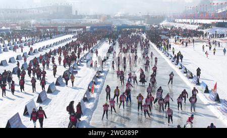 I piloti competono nella gara di pattinaggio durante la prima China Jilin Songhua River Ice Skating Marathon nella contea di Jingyu, Baishan City, nord-est del CH Foto Stock