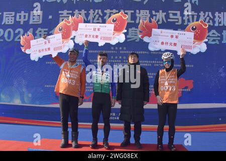 I piloti competono nella gara di pattinaggio durante la prima China Jilin Songhua River Ice Skating Marathon nella contea di Jingyu, Baishan City, nord-est del CH Foto Stock