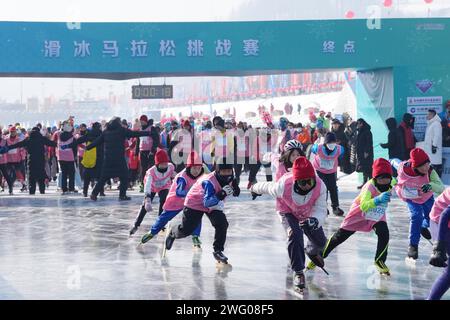 I piloti competono nella gara di pattinaggio durante la prima China Jilin Songhua River Ice Skating Marathon nella contea di Jingyu, Baishan City, nord-est del CH Foto Stock