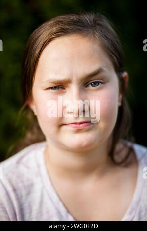 Un ritratto di 12 anni solleva le sopracciglia, facendo un volto curioso. Foto Stock