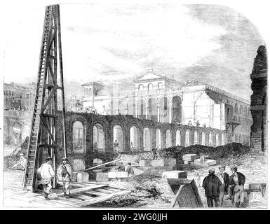 Demolizione del mercato di Hungerford per fare spazio alla stazione ferroviaria di Charing-Cross, [Londra], 1862. "La nostra vista è presa dall'estremità inferiore di Villiers-Street, dove attualmente è possibile accedere al molo delle barche a vapore. Queste rovine presentano un aspetto singolare: Frammenti di mattoni, volte a metà aperte, con qui e là rotte rampe di scale che conducono ad esse, e colonne prostrate, danno l'idea che qui sia stato in gioco un giovane terremoto. I lavori del nuovo ponte ferroviario si stanno avvicinando così rapidamente alla riva da richiedere l'immediata distruzione del mercato. La prima porte Foto Stock