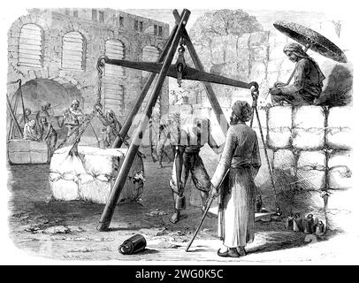 Pesatura del cotone a Bombay per il mercato inglese, 1862. Qui '...le balle sono sbarcate da Surat, Baroche, Cambay e altre parti di Guzerat, Kuttyawa e Cutch...a causa dell'assenza di buone strade per i veicoli, il normale mezzo di trasporto era, fino a poco tempo fa, per mezzo di boschetti... questa costosa e noiosa modalità di trasporto ha ora, tuttavia, dato spazio in una misura alla ferrovia, anche se deve ancora essere impiegato per portare le balle di cotone dai quartieri periferici... alle stazioni più vicine sulla linea ferroviaria. La balla di cotone pesa circa 7 cwt., e, fino a quando non viene compressa da t. Foto Stock