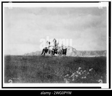 Le pianure del Dakota-Sioux, c1905. Tre indiani Sioux a cavallo su pianure con formazione rocciosa sullo sfondo. Foto Stock