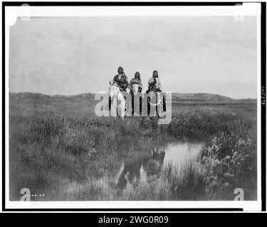 Nella terra dei Sioux, c1905. Tre indiani Sioux a cavallo di fronte allo stagno sulle pianure. Foto Stock