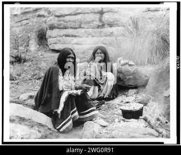 Due donne indiane Apache al fuoco, pentola davanti ad una, c1903. Foto Stock