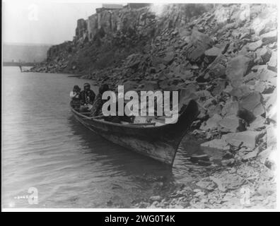 Sulla Columbia-Wishham (cioè, Wishram), c1910. Gli indiani Tlakluit, seduti in canoa, vicino alle rocce sul bordo dell'acqua. Foto Stock