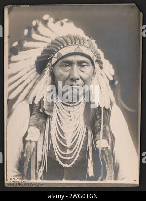 Joseph-Nez PERCé, c1903. La fotografia mostra il capo Giuseppe, un ritratto a metà lunghezza, rivolto verso la parte anteriore, che indossa un cofano da guerra e diverse collane. Foto Stock