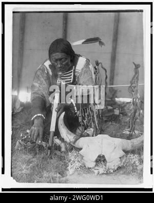 Saliva, c1907. Dakota uomo con calumet inginocchiato dall'altare all'interno di tipi. Foto Stock